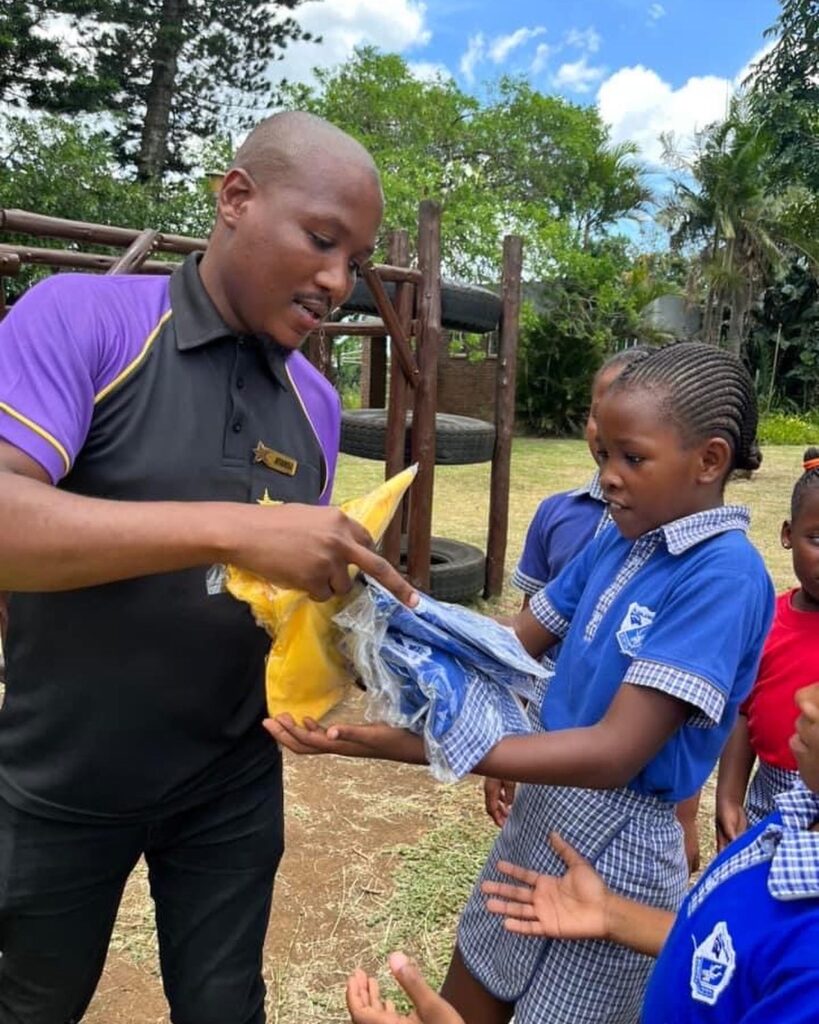 hollywoodfoundation-2. Representative from Hollywood Foundation handing over uniforms to a learnerThe Sharks and the Hollywood Foundation partner for the Back to School campaign Hollywoodbets iBranch MASTER