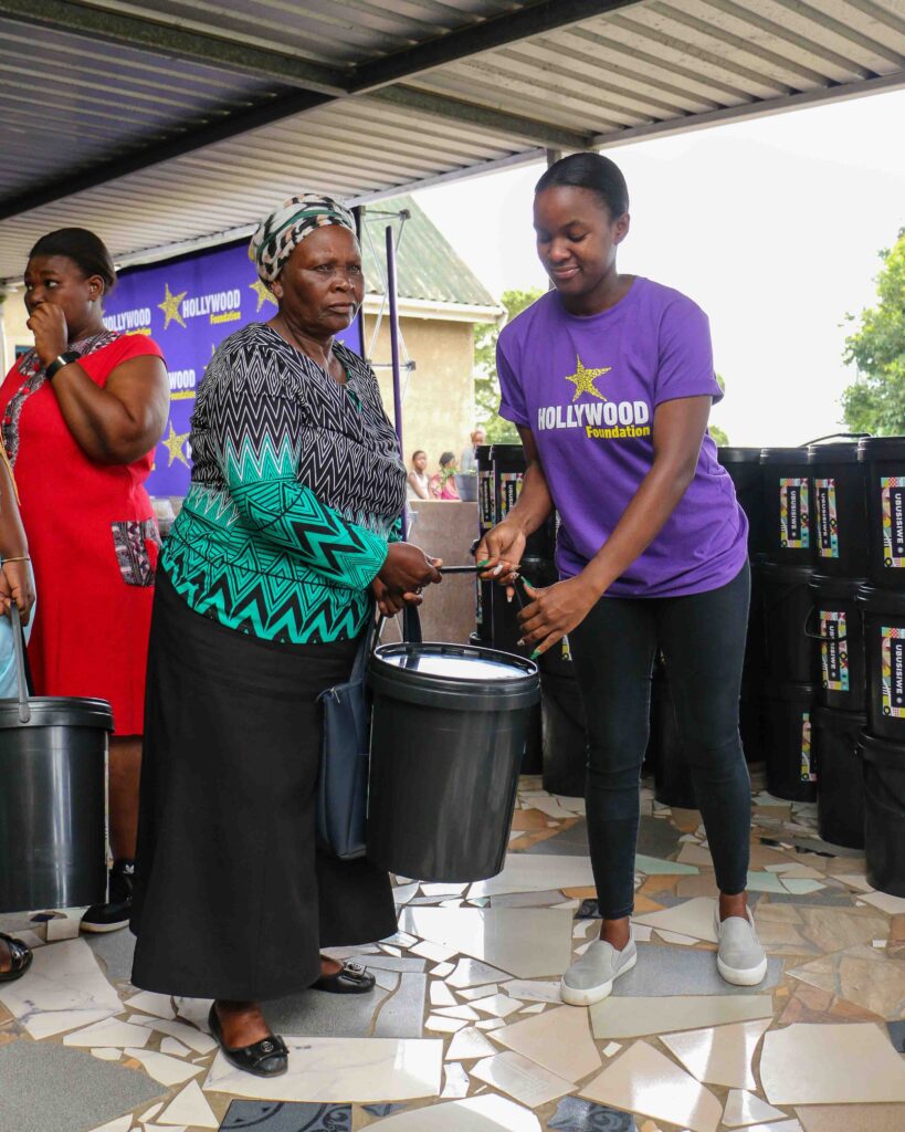 hollywoodfoundation-5. A representative from Hollywoodbets hands over a bucket to an elderly womanHollywood Foundation spreads some festive cheer with the 2022 Bucket DriveCorporate Social Investment Programme