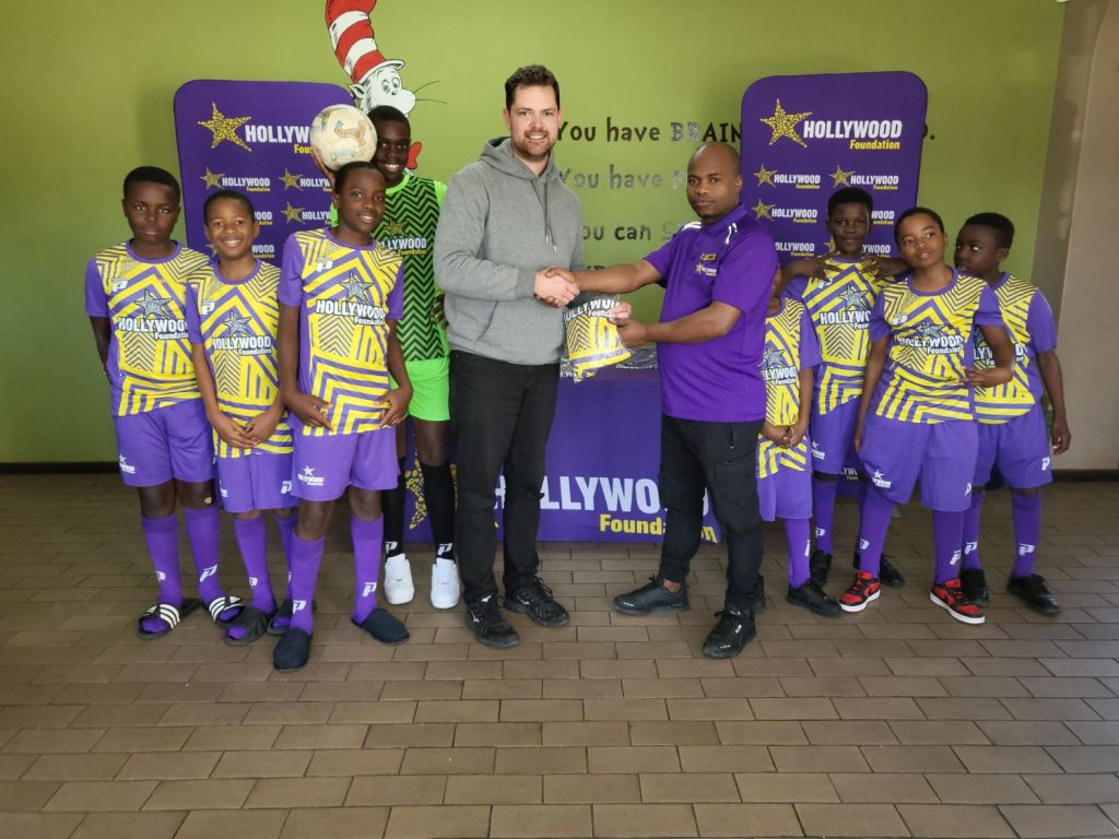 hollywoodfoundation-Hollywood Foundation Team and Montague Gardens branch representatives hand over new soccer kits to Ysterplaat Primary SchoolHollywood Foundation’s Corporate Social Investment (CSI) Initiative Supports Ysterplaat Primary School Soccer TeamsHollywoodbets iBranch MASTER